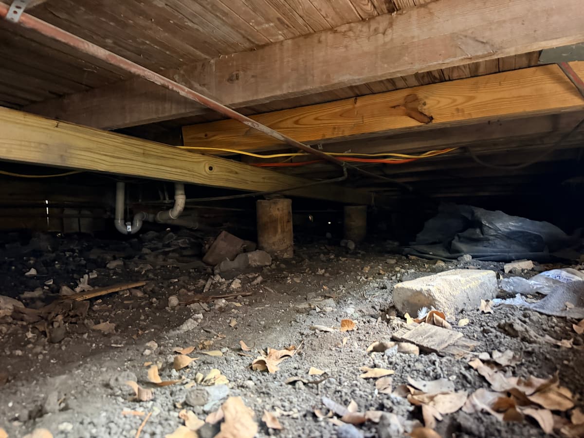 Cluttered pier & beam crawl space before repair
