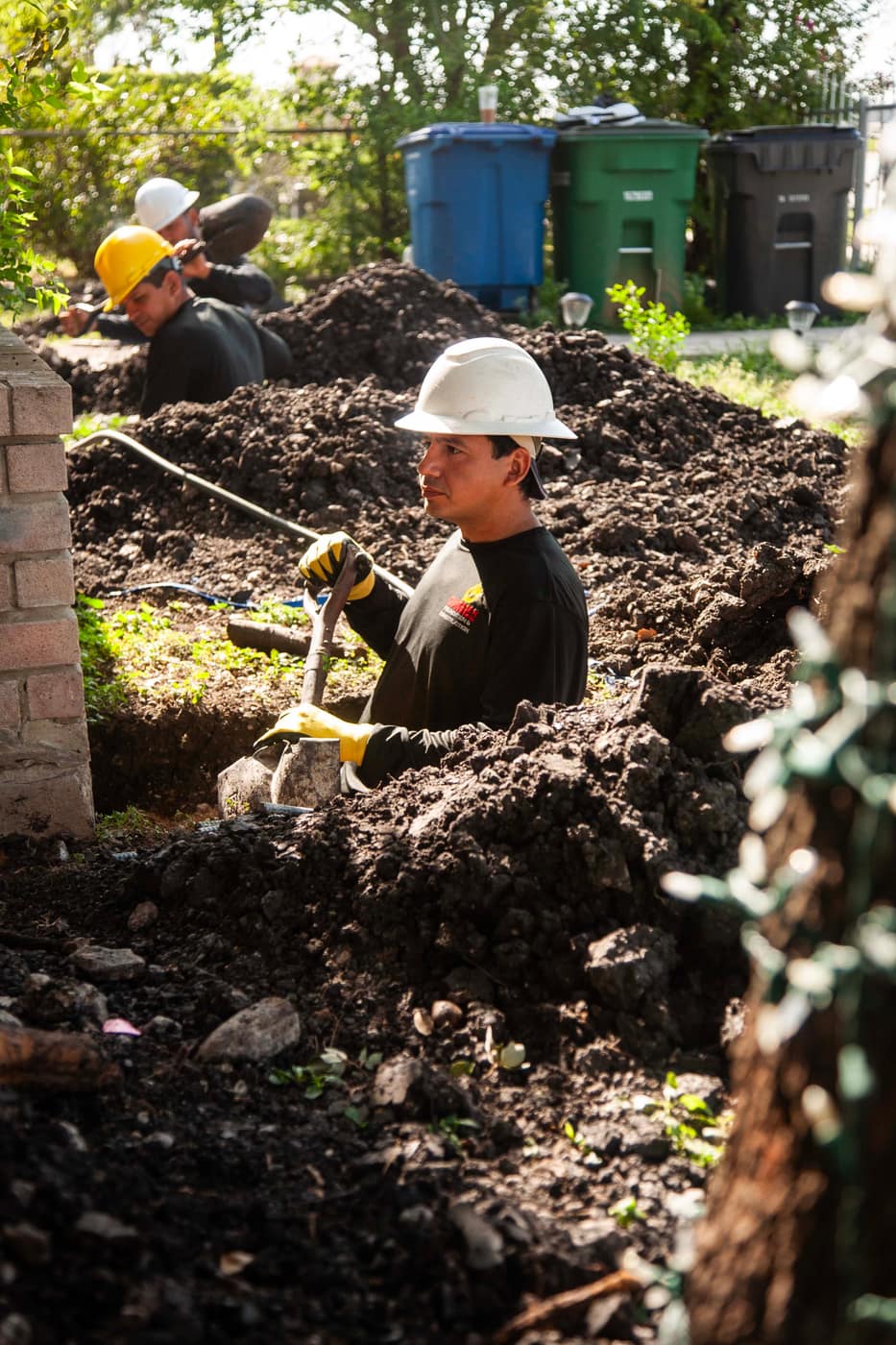 Technician excavating a foundation pier location