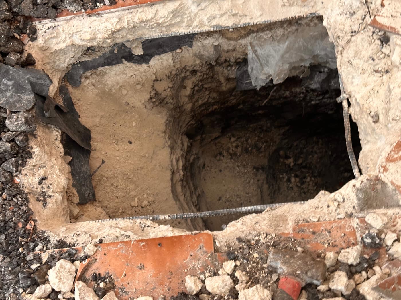 Deep concrete foundation pier installed beneath a brick home