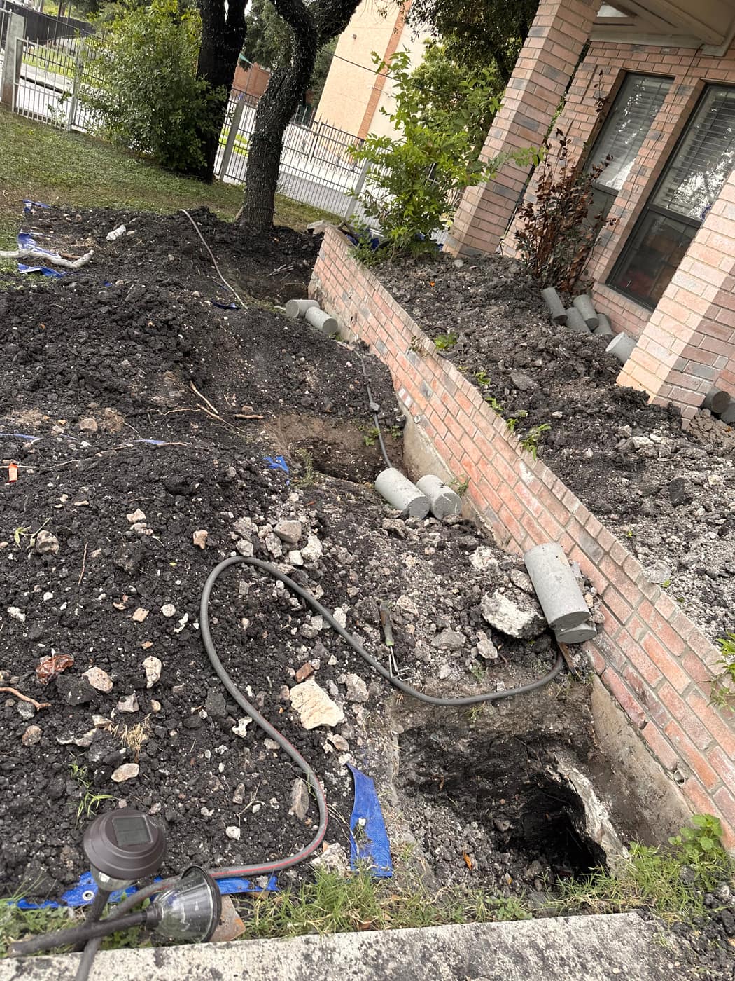 Excavated foundation piers along a brick home