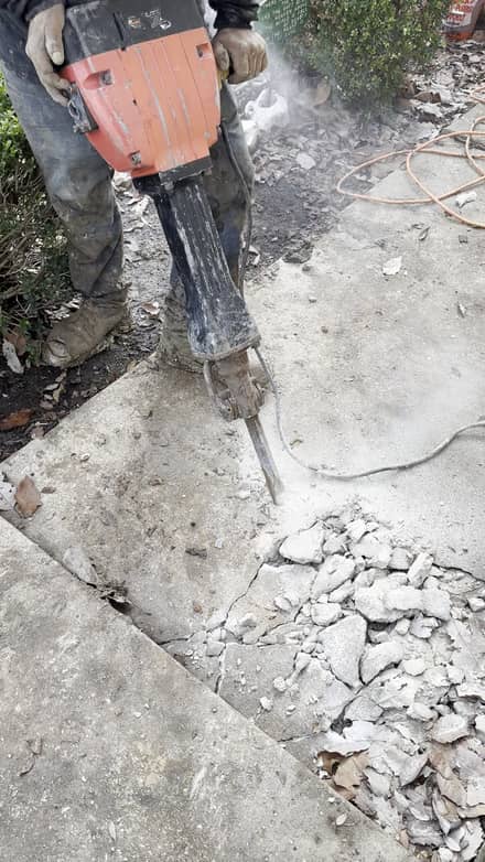 Sage FX technician breaking concrete with a jackhammer