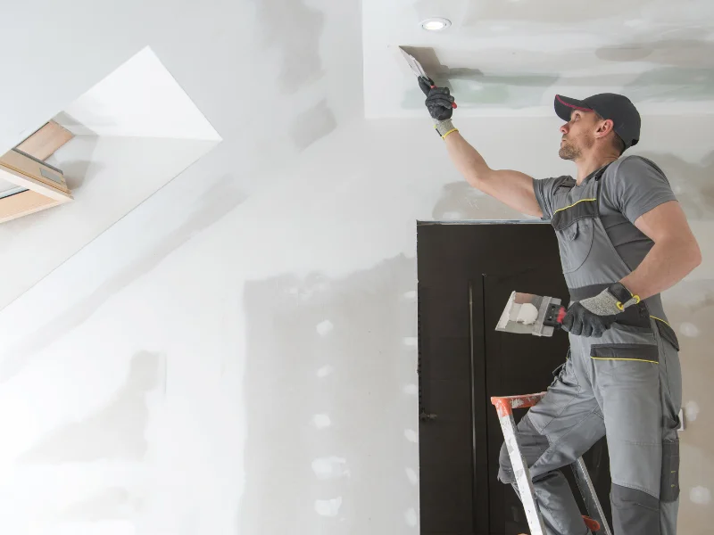 An image showing a house with visible foundation cracks and a repair crew working on it.