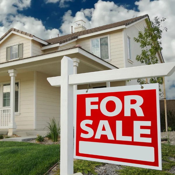 An image showing a well-maintained home foundation with a For Sale sign.